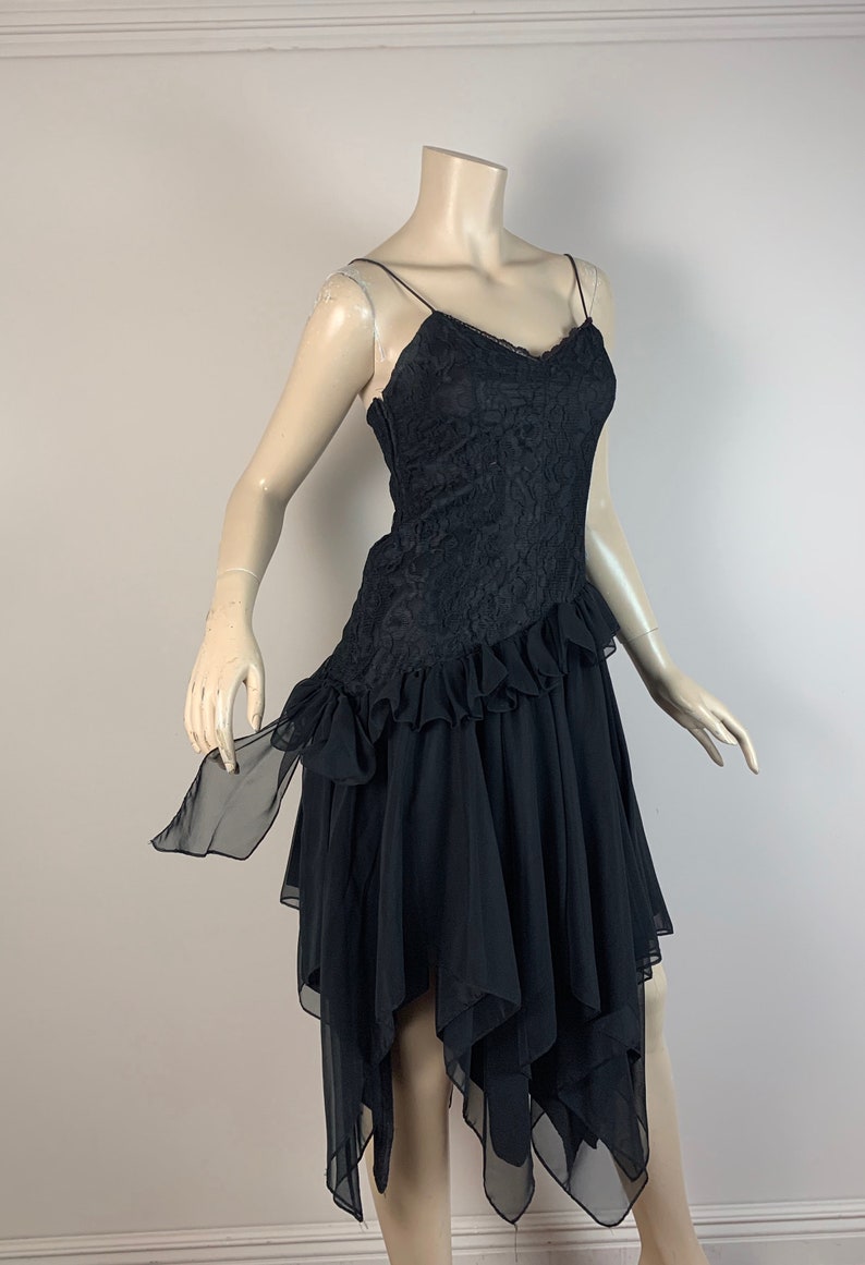 May include: A black lace and chiffon dress with a ruffled skirt and a sweetheart neckline.