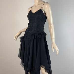 May include: A black lace and chiffon dress with a ruffled hem and a layered, asymmetrical skirt.