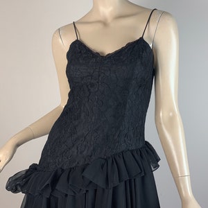 May include: A black lace dress with a ruffled skirt and spaghetti straps.