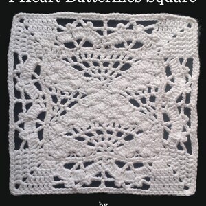 May include: A square, white crocheted doily with a detailed openwork design. The pattern features heart and butterfly motifs, creating a delicate and intricate texture. The edges are neatly finished with a solid border.