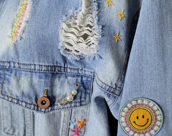 Upcycled denim jean jacket with plaid patches, hand embroidery, pins