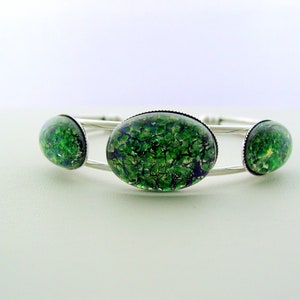 May include: Silver bangle bracelet with three green and blue oval-shaped glass cabochons.