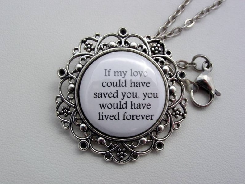 May include: Silver necklace with a round pendant featuring a white background and black text that reads "If my love could have saved you, you would have lived forever".