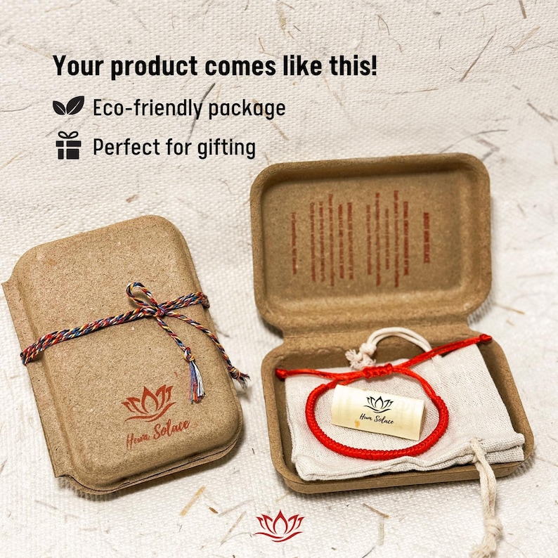 Puede incluir: Una caja de cart&oacute;n marr&oacute;n atada con una cuerda multicolor, y una segunda caja abierta, que revela una pulsera roja sobre una tela blanca. El texto "Your product comes like this!" y "Eco-friendly package" son visibles.
