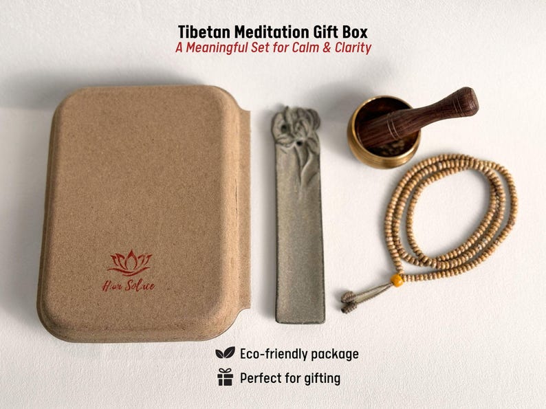 May include: A Tibetan Meditation Gift Box set includes a brown box, a gray incense holder, a brass singing bowl with a wooden striker, and a beaded mala. The box has the text "Hur Solue" and "Tibetan Meditation Gift Box". The set is an eco-friendly package.