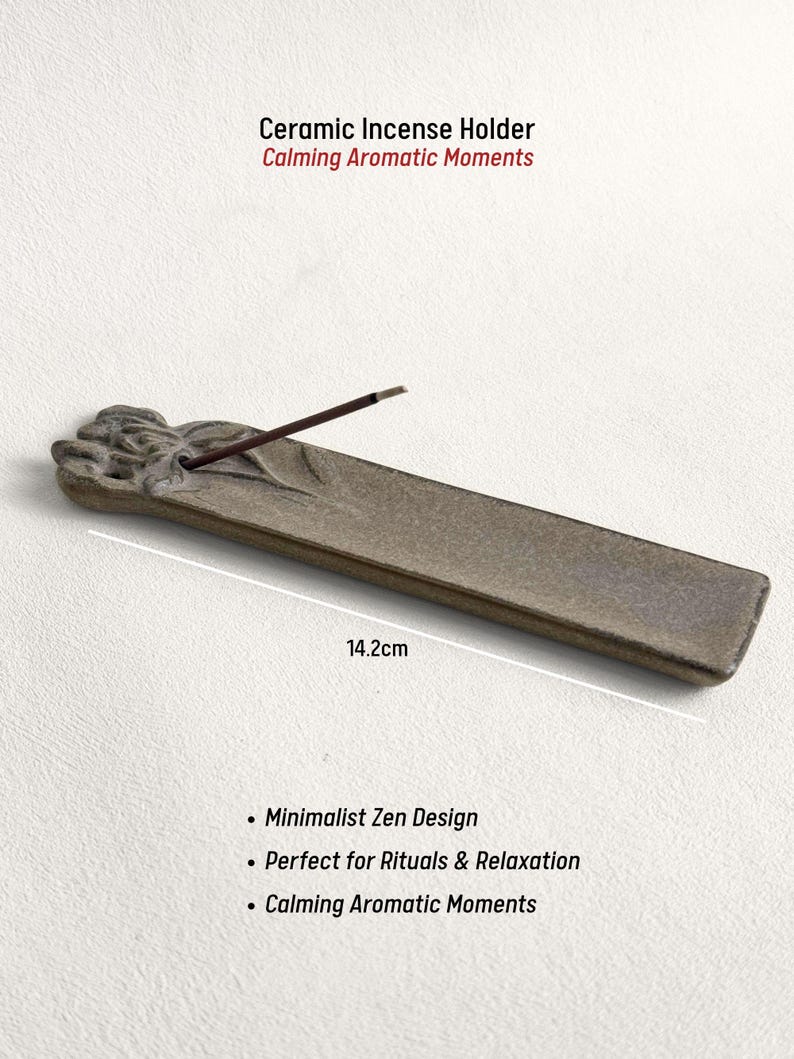 May include: A ceramic incense holder, 14.2cm long, with a minimalist Zen design. The holder is a muted gray color and features the text "Ceramic Incense Holder Calming Aromatic Moments". An incense stick is placed in the holder.