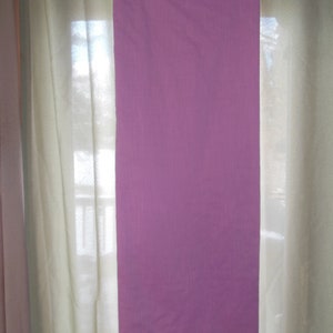 May include: A long, rectangular piece of fabric in a light purple color. The fabric has a subtle texture and is hanging from a black hanger.