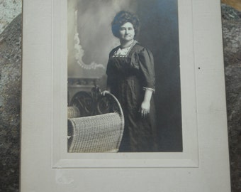 vintage parlor photo of older woman standing with her hand on a wicker chair - Kellogg Studio, Cuba, NY