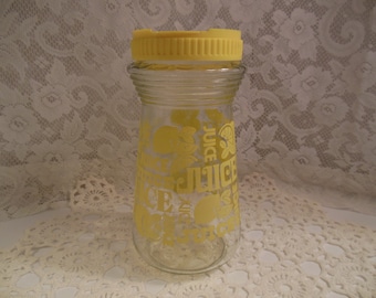 Vintage glass juice serving jar adorned with oranges and lemons with yellow plastic lid