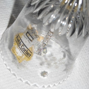 K&ouml;nnte beinhalten: Eine klare Glasglocke mit einem Kristall, der im Inneren h&auml;ngt. Die Glocke hat einen gewellten Rand und ein Etikett mit der Aufschrift "Webb Corbett, Made in England, Crystal Bell".