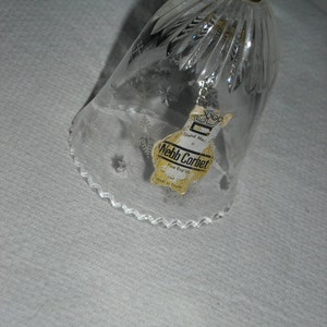 K&ouml;nnte beinhalten: Eine klare Glasglocke mit einem gewellten Rand und einem Schneeflockenmuster. Die Glocke tr&auml;gt ein Etikett mit der Aufschrift "Webb Corbett, Hand Made, Fine English Crystal, Made in England".