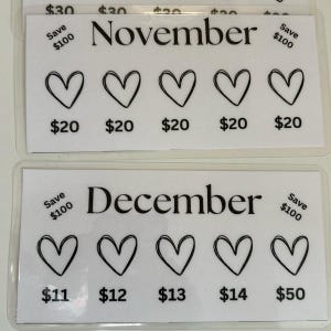 May include: Two white cards with black text and hearts. The top card says "November" and has five hearts with prices of $20 and a "Save $100" note. The bottom card says "December" and has five hearts with prices of $11, $12, $13, $14, and $50 and a "Save $100" note.