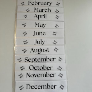 May include: A set of twelve white cards with black text, each card features a month of the year and a dollar amount. The cards are arranged vertically in a stack. The bottom card has five hearts and dollar amounts below each heart.