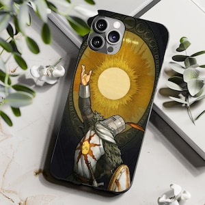 May include: Black phone case with a detailed illustration of a knight raising a hand towards a golden sun. The design includes a shield and the text "Praise the sun".