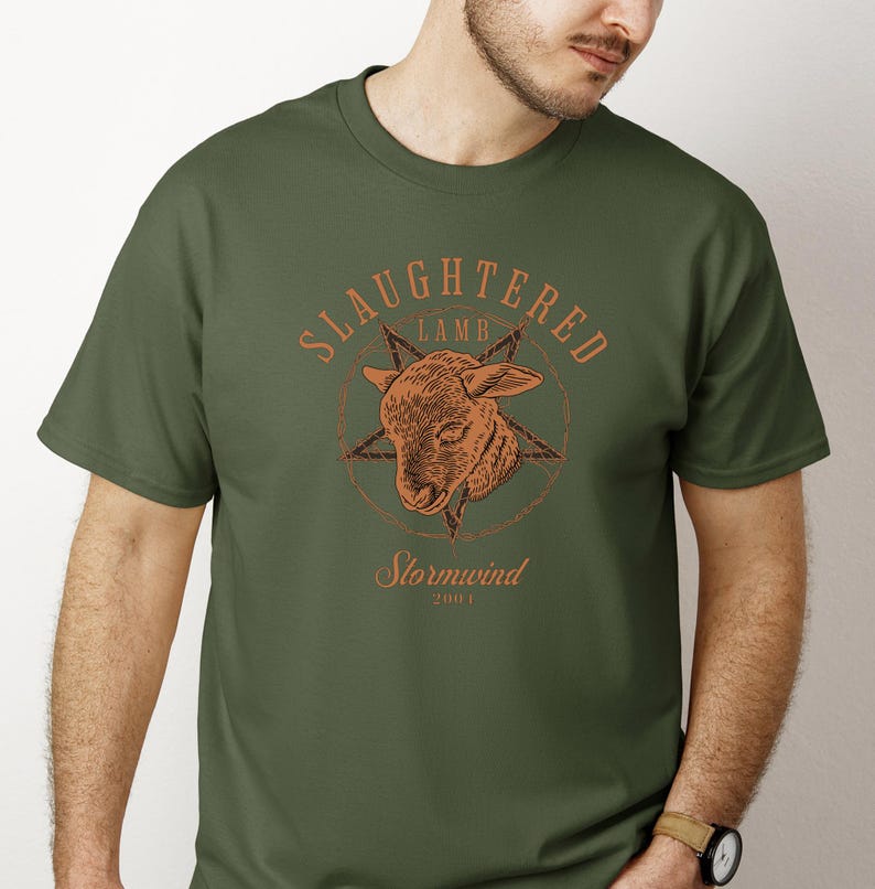 May include: Olive green t-shirt featuring a detailed illustration of a lamb's head within a star, with the words "SLaughtered Lamb" above and "Stormwind 2001" below in a rustic font.