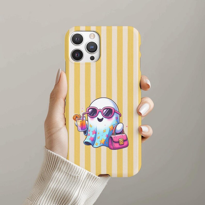 May include: A phone case with a yellow and white striped pattern. The case features a cartoon ghost wearing pink sunglasses and holding a cocktail. The ghost also carries a pink handbag. The case is designed for a smartphone.