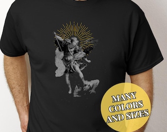 May include: Black t-shirt with a graphic of an angel with a sword, stepping on a demon. The angel has a halo and is surrounded by a golden sunburst. The text "MANY COLORS AND SIZES" is on a yellow circle.