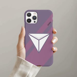 May include: Purple and pink phone case with a white triangle logo and the word "IKORA" printed on the case.