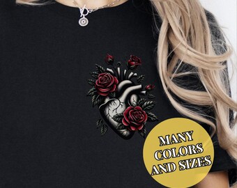 May include: Black t-shirt with a graphic of a human heart entwined with red roses. The text "MANY COLORS AND SIZES" is on a yellow circle.