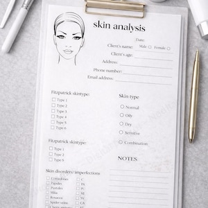 May include: A skin analysis form on a clipboard with a gold clip, a pen, and skincare products. The form includes sections for client information, skin type, and skin disorders. Text on the form reads "skin analysis".