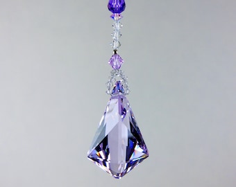 May include: A hanging crystal suncatcher ornament featuring a large, faceted, light purple teardrop-shaped pendant suspended by a vertical strand of clear and purple crystal beads. The text LILLI HEART DESIGNS 2024 is visible at the top.
