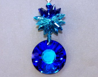 May include: A blue crystal suncatcher with a round, faceted crystal at the bottom and a starburst of smaller crystals at the top.  The crystals are a mix of blue and teal.