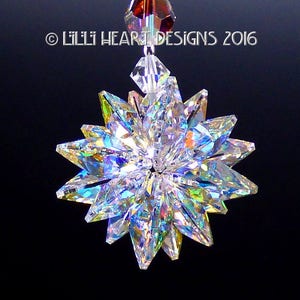 Puede incluir: Un atrapasol de cristal con un diseño de estrella, que presenta colores arcoíris iridiscentes. El atrapasol está hecho de cristal transparente y tiene un lazo para colgar en la parte superior.