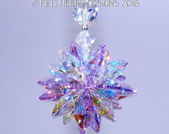 Puede incluir: Un atrapasol de cristal con un diseño de estrella estrellada de color púrpura iridiscente que cuelga de una cadena de cristal transparente. © LILI HEART DESIGNS 2016
