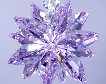 May include: A purple crystal star ornament with a faceted design. The star is hanging from a clear string.
