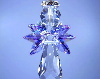 May include: A clear crystal angel ornament with purple accents. The ornament has a faceted teardrop shape at the bottom, with a starburst design in the middle. The top has a silver ring and a clear crystal bead. Text reads: © Lilli Heart Designs 2014.