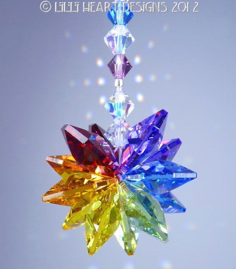 Puede incluir: Un atrapasol de cristal arco&iacute;ris con un dise&ntilde;o de estrella. El atrapasol est&aacute; hecho de cristales facetados en tonos de rojo, naranja, amarillo, verde, azul, &iacute;ndigo y violeta. El atrapasol est&aacute; suspendido de una cadena plateada.