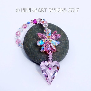 May include: Pink crystal heart suncatcher with a crystal flower design and a beaded chain.  &copy; Lili Heart Designs 2017