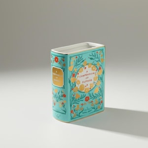 Könnte beinhalten: Eine türkisfarbene Keramikvase in Buchform mit goldenen Akzenten und der Aufschrift "A Compendium of Flowers". Die Vase zeigt rote und goldene Blumenmuster. Die Vase hat eine rechteckige Form mit weißem Innenraum.