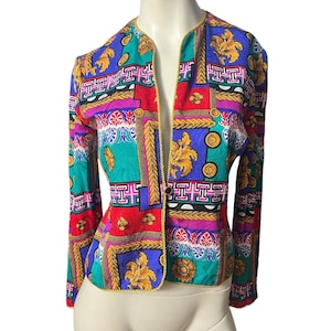 May include: A colourful patterned blazer with a gold trim and a button closure. The pattern features geometric shapes, floral motifs, and gold accents.