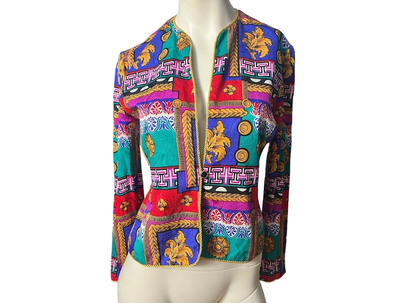 May include: A colourful patterned blazer with a gold trim and a button closure. The pattern features geometric shapes, floral motifs, and gold accents.