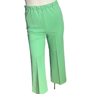 May include: Light green pants with an elastic waistband and a slight flare at the hem. The pants are a solid color and appear to be made of a lightweight fabric. The pants are displayed on a mannequin.