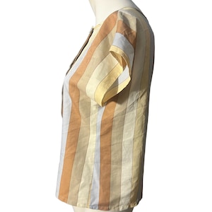 May include: A striped short-sleeved blouse with a scoop neck. The stripes are in shades of yellow, orange, and brown.
