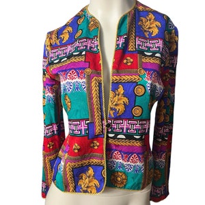 May include: A colourful patterned blazer with a gold trim. The blazer has a geometric design with a mix of red, blue, green, pink, and gold.