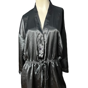 Puede incluir: Una bata de satén negra de manga larga, cuello en V y cintura con cordón.