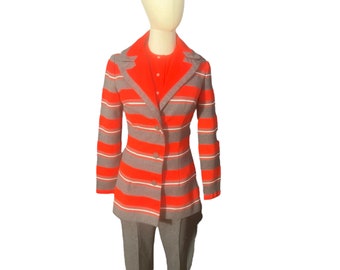 May include: A red and gray striped blazer with a button closure. The blazer has long sleeves and a collar.