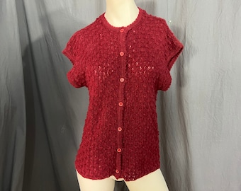 Könnte beinhalten: Ein maroner Strickcardigan mit kurzen Ärmeln und Knopfleiste.