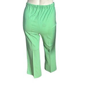 May include: Light green pants with an elastic waistband. The pants are a solid color and have a slight flare at the bottom of the legs. The fabric appears to be a lightweight material.