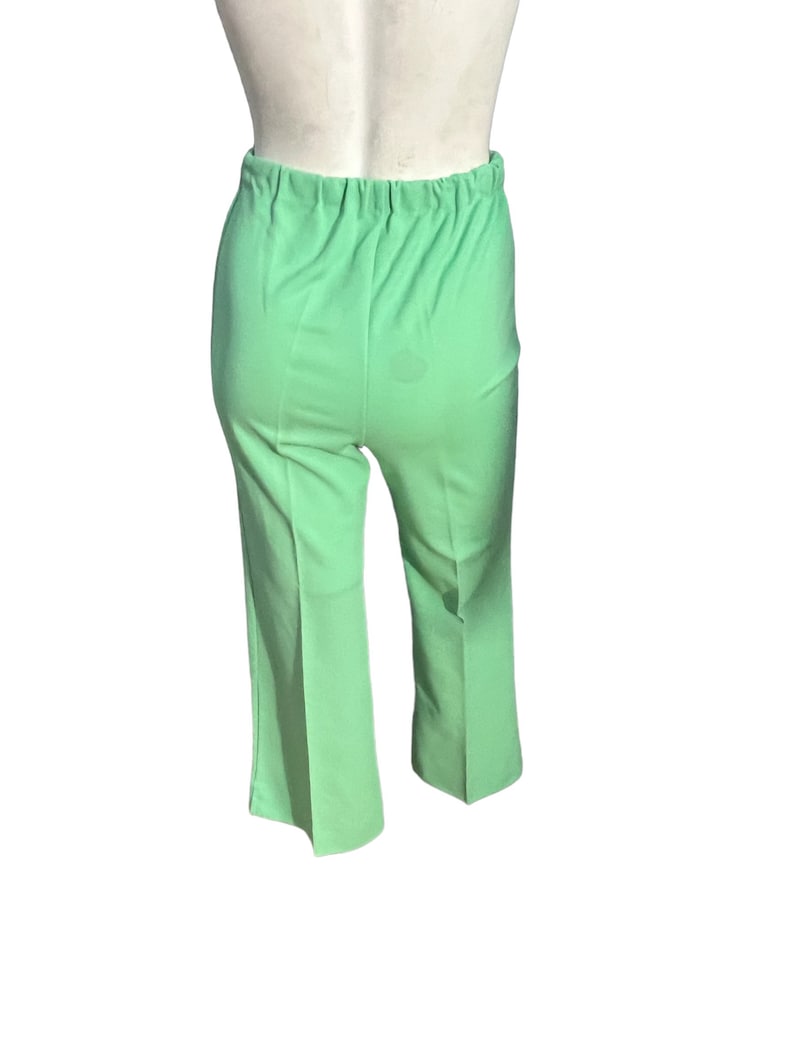 May include: Light green pants with an elastic waistband. The pants are a solid color and have a slight flare at the bottom of the legs. The fabric appears to be a lightweight material.