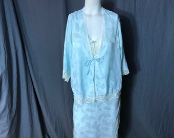 May include: A light blue satin nightgown with a leaf pattern and lace trim. The nightgown has a matching robe with a tie at the waist.
