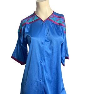 May include: A blue button-up nightgown with a pink and teal geometric pattern on the shoulders.