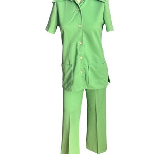 May include: A vintage lime green two-piece pantsuit. The short-sleeved collared shirt has two front pockets and button closures. The matching pants are flared. The outfit is displayed on a mannequin.