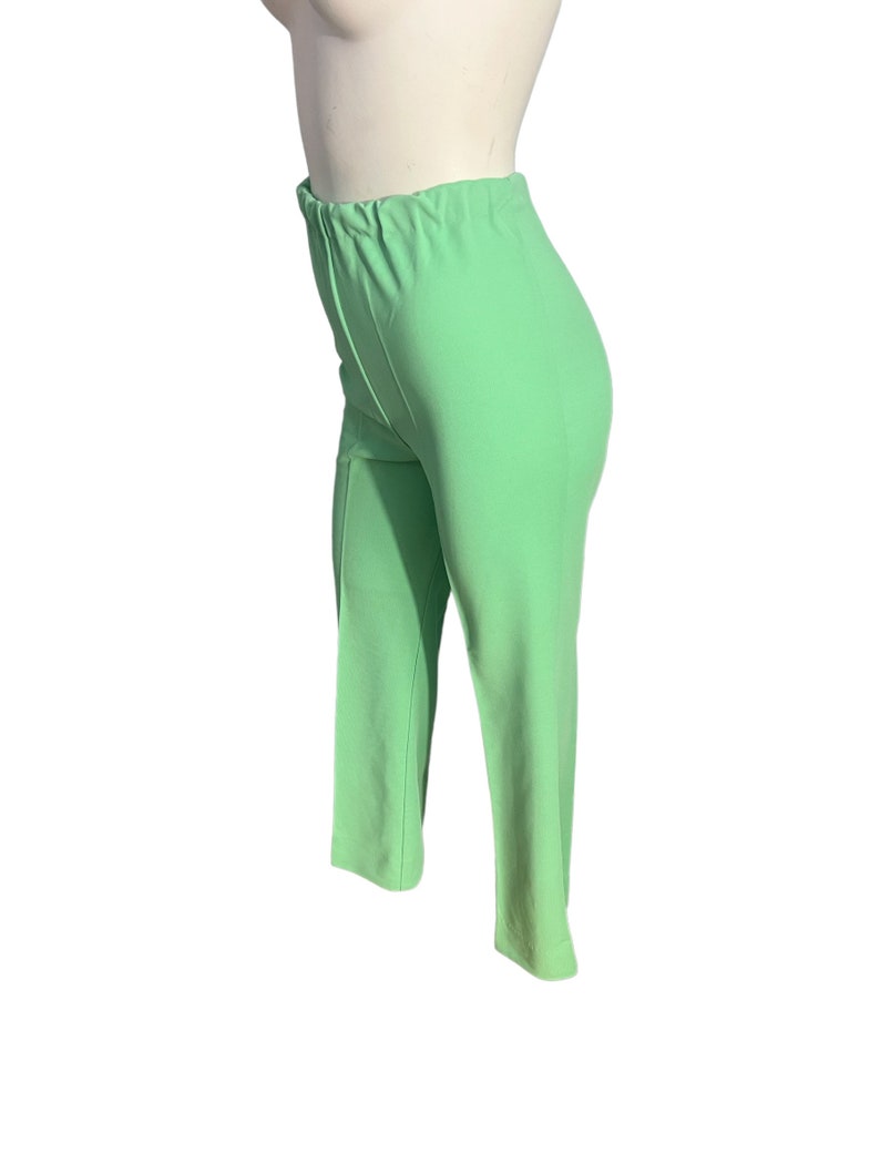 May include: Light green pants with an elastic waistband. The pants are a solid color and have a straight leg design. The fabric appears to be a lightweight material, suitable for warmer weather.