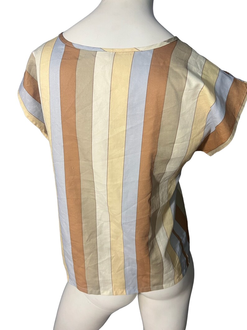 May include: A striped short-sleeved top with a scoop neck. The stripes are in shades of brown, beige, and blue.