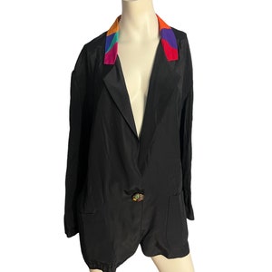 May include: A black blazer with a colorful patterned collar. The collar is made of a different fabric than the blazer and has a geometric design in shades of orange, red, purple, and green.