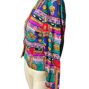 May include: A colourful, patterned jacket with a gold trim. The jacket features a variety of geometric and floral designs in shades of red, blue, green, pink, and yellow.